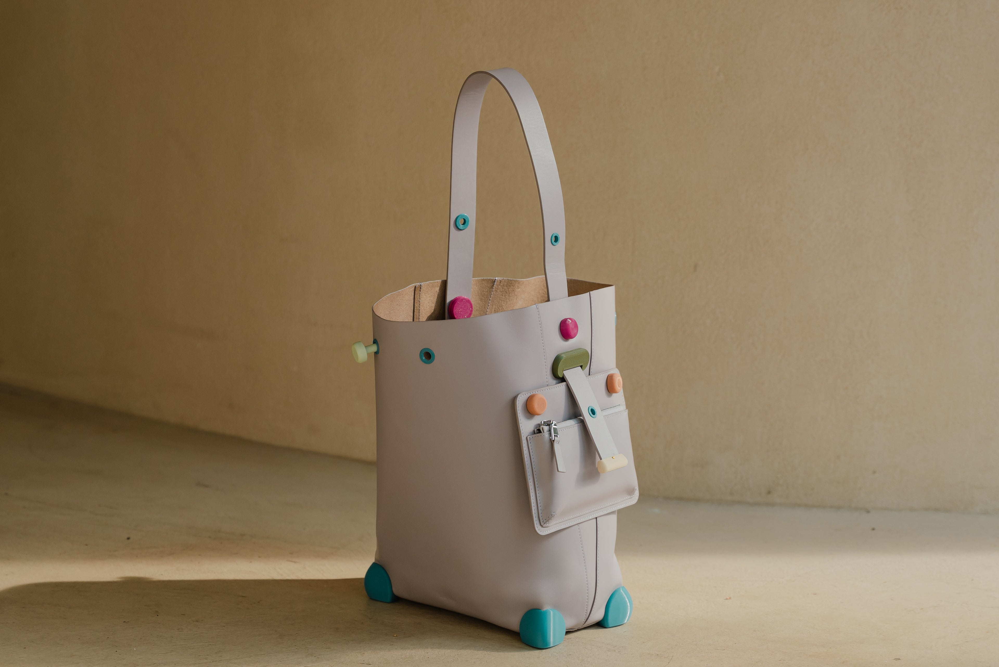 leather bag bag with colourful 3d printed hardware on a beige background